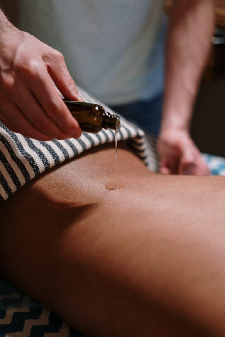 De l'huile de massage versé sur le corps d'un client